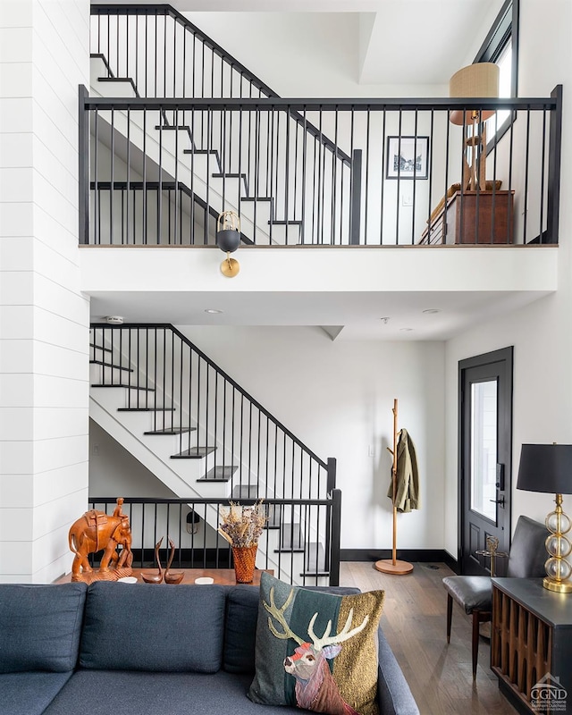 352 Columbia St, Hudson, NY 12534 - living area featuring wood finished floors, stairway, a towering ceiling, and baseboards