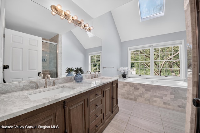 172 Shields Rd, Red Hook, NY 12571 - full bathroom featuring a skylight, lofted ceiling, double vanity, tile patterned flooring, and a garden tub