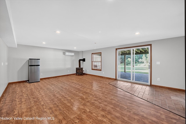 172 Shields Rd, Red Hook, NY 12571 - unfurnished living room featuring a wood stove, a wall mounted air conditioner, recessed lighting, and wood finished floors