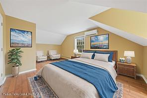 172 Shields Rd, Red Hook, NY 12571 - bedroom featuring wood finished floors, vaulted ceiling, and an AC wall unit