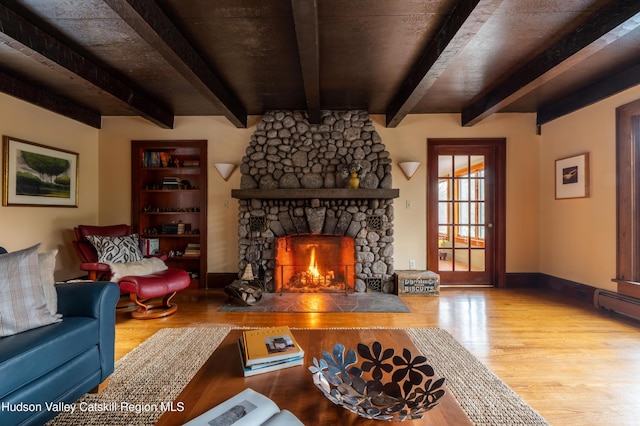 living room with a fireplace, light hardwood / wood-style floors, and beamed ceiling