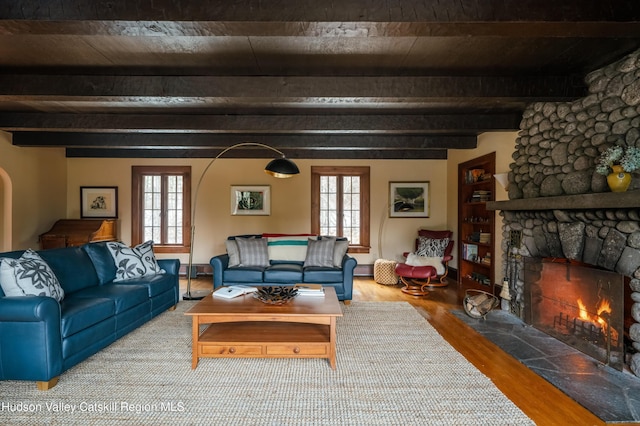 living room with beamed ceiling, a fireplace, and hardwood / wood-style floors