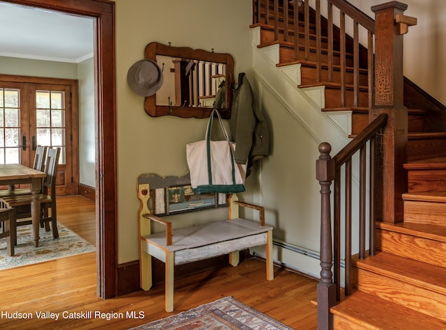 stairs with ornamental molding, hardwood / wood-style floors, and french doors