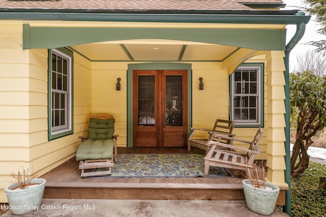 view of exterior entry with french doors and a porch