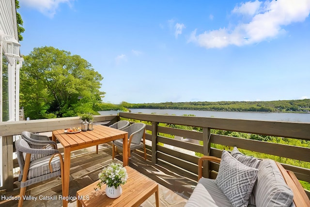 balcony with a water view and an outdoor hangout area