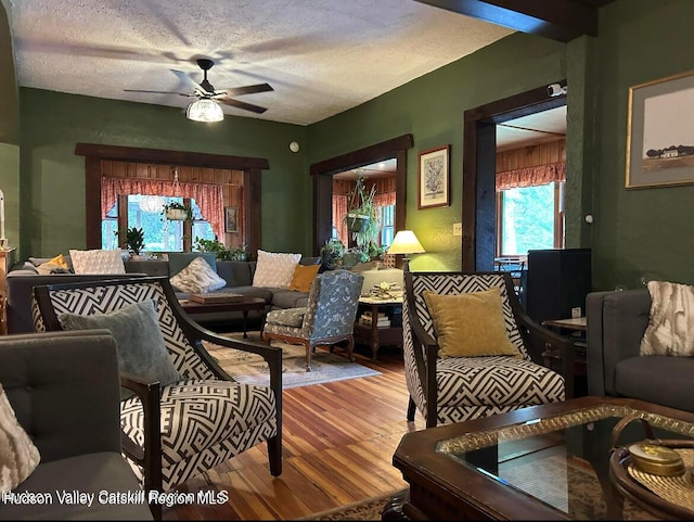 living room with hardwood / wood-style floors, a textured ceiling, and ceiling fan