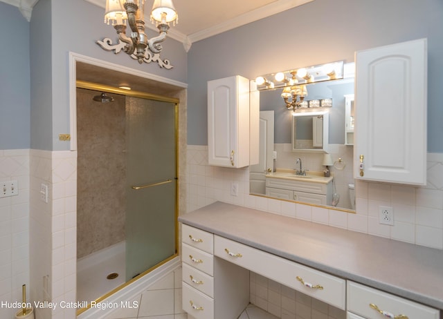 bathroom with vanity, backsplash, tile patterned floors, ornamental molding, and a shower with shower door