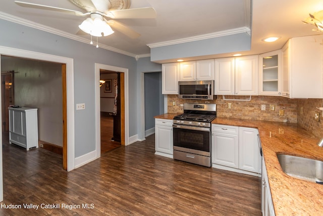 kitchen with white cabinets, appliances with stainless steel finishes, and light stone countertops