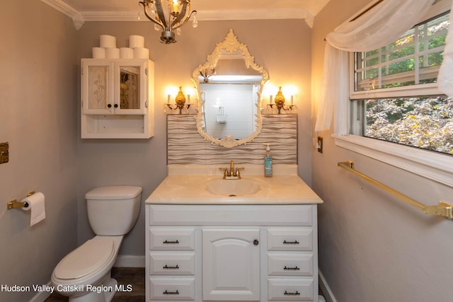 bathroom with vanity, toilet, and crown molding