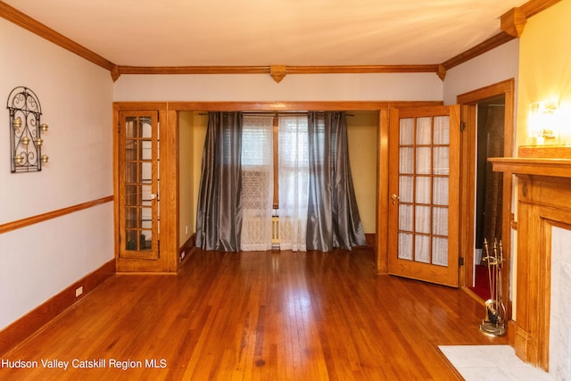 spare room featuring french doors, wood-type flooring, and ornamental molding