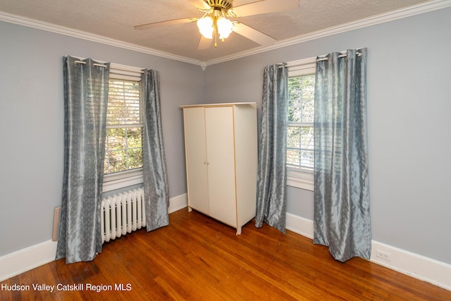 unfurnished bedroom with ceiling fan, radiator heating unit, crown molding, hardwood / wood-style floors, and a textured ceiling