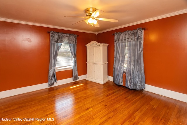 spare room featuring ceiling fan, wood-type flooring, and crown molding