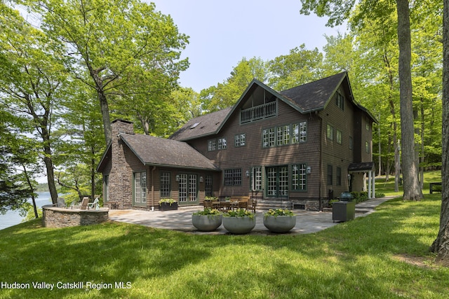 196 Wellington Ln, Cooperstown, NY 13326 - back of property featuring a patio, a yard, a chimney, and roof with shingles