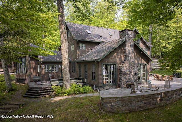 196 Wellington Ln, Cooperstown, NY 13326 - rear view of house featuring a wooden deck, a patio area, a chimney, and a shingled roof