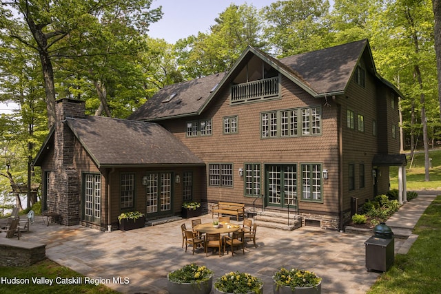 196 Wellington Ln, Cooperstown, NY 13326 - back of property featuring french doors, a chimney, a patio area, roof with shingles, and entry steps