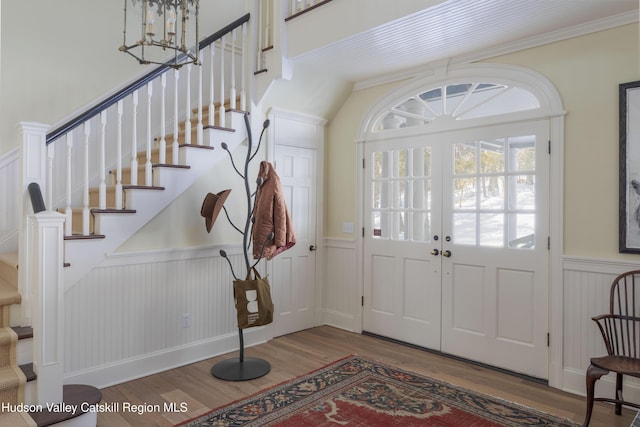 196 Wellington Ln, Cooperstown, NY 13326 - entrance foyer with wainscoting, stairway, wood finished floors, a chandelier, and crown molding