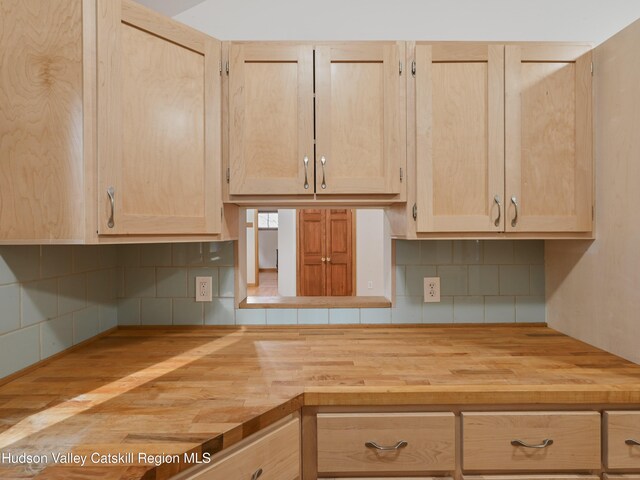 kitchen featuring decorative backsplash, light brown cabinetry, wooden counters, and hardwood / wood-style flooring