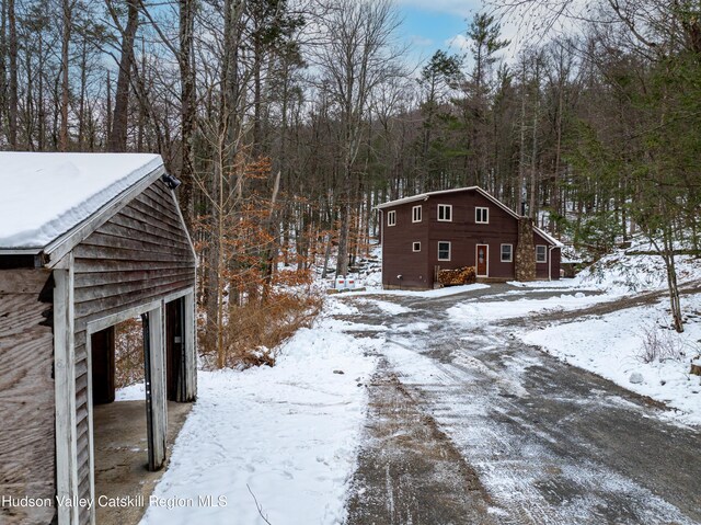 yard layered in snow with an outbuilding