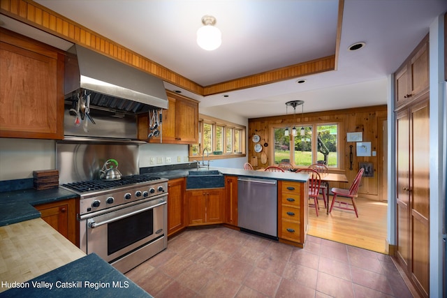 11 Louie Way, Woodstock, NY 12498 - kitchen with stainless steel appliances, a sink, a peninsula, brown cabinets, and range hood