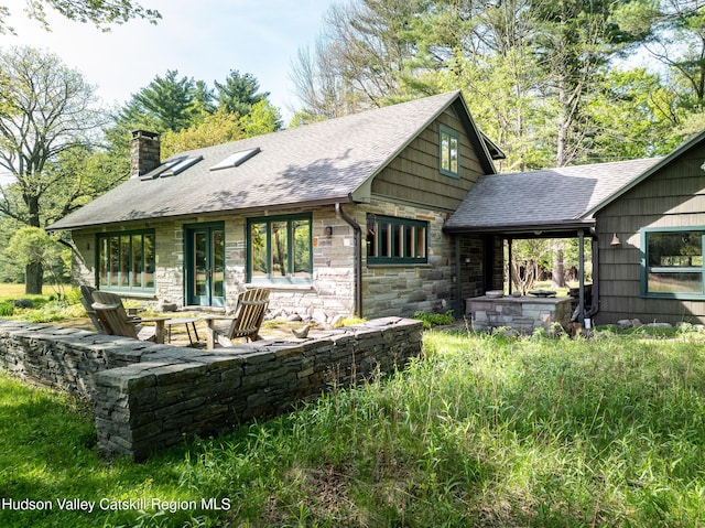 11 Louie Way, Woodstock, NY 12498 - view of front of home with a chimney, roof with shingles, stone siding, and a patio area
