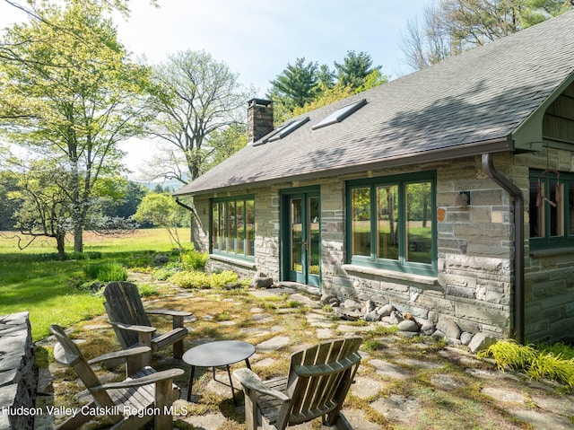 11 Louie Way, Woodstock, NY 12498 - back of house featuring stone siding, roof with shingles, and a chimney