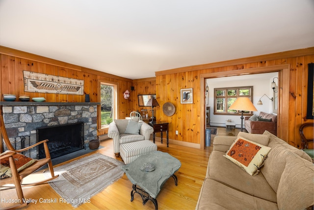 11 Louie Way, Woodstock, NY 12498 - living area with plenty of natural light, wooden walls, a stone fireplace, wood finished floors, and a baseboard heating unit