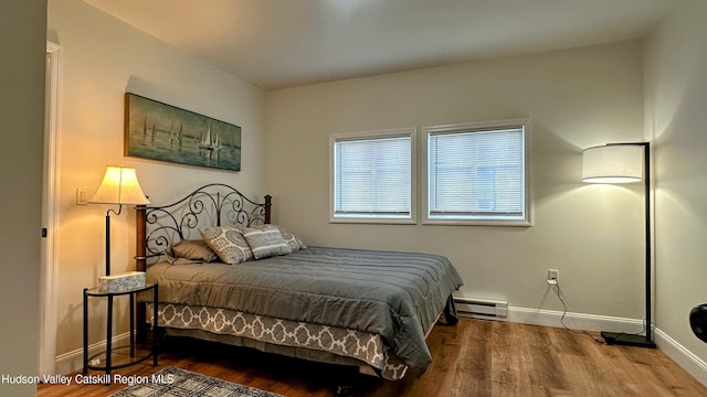 bedroom featuring baseboard heating and wood-type flooring