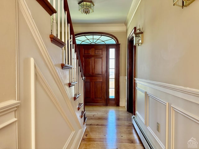 524 County Route 17, North Chatham, NY 12132 - entryway with a baseboard heating unit, a decorative wall, light wood finished floors, stairway, and wainscoting