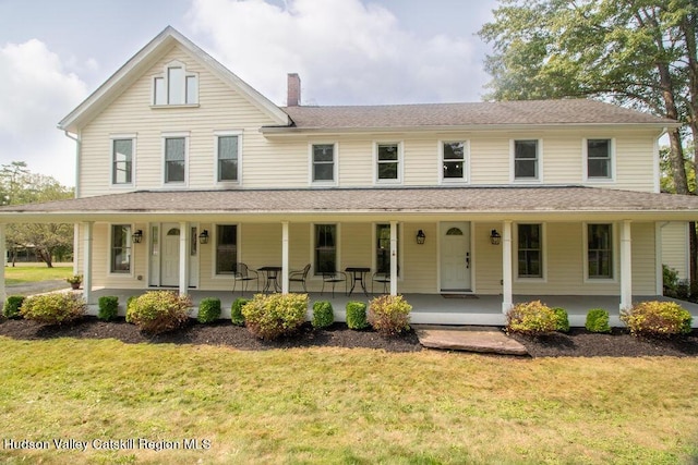 farmhouse inspired home with covered porch and a front lawn