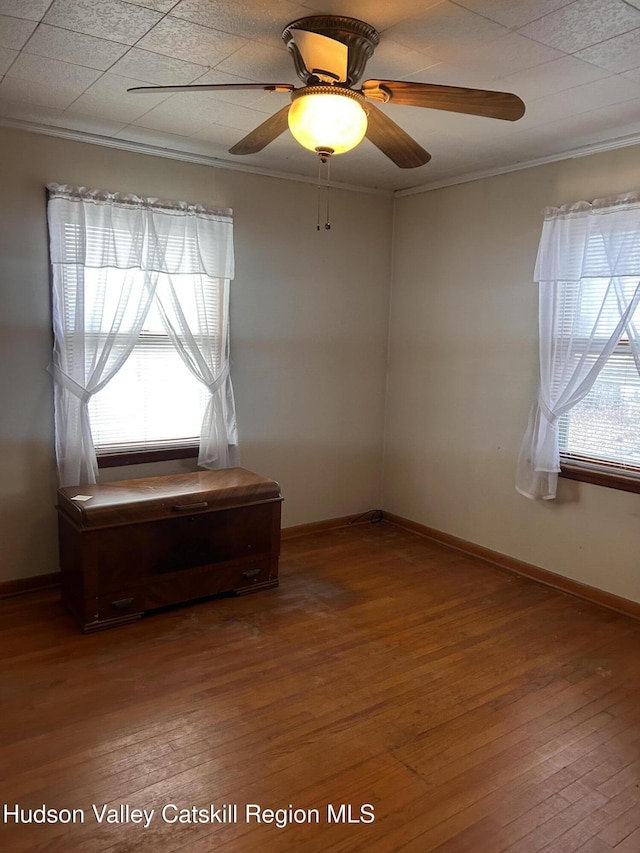 unfurnished room with ceiling fan, crown molding, and wood-type flooring