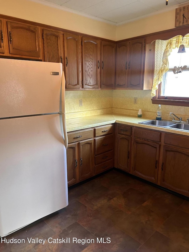 kitchen featuring decorative backsplash, sink, and white refrigerator