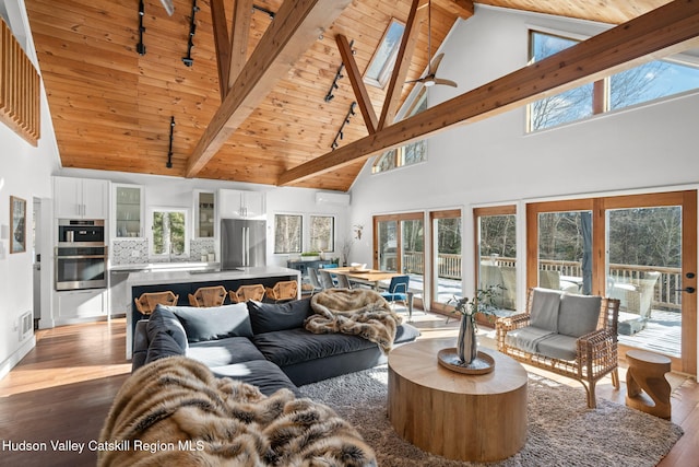 living room with a skylight, wooden ceiling, dark hardwood / wood-style flooring, a wall unit AC, and beamed ceiling