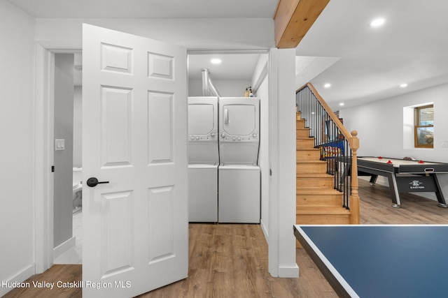 recreation room featuring hardwood / wood-style flooring and stacked washer and dryer