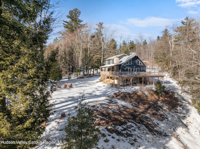 snow covered house with a wooden deck