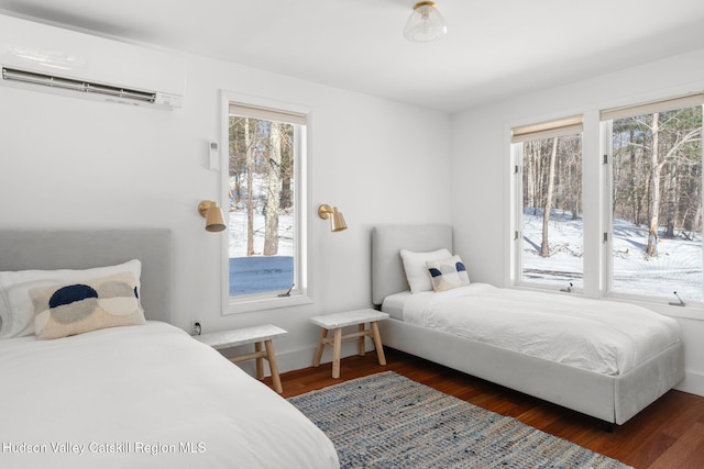 bedroom with dark hardwood / wood-style floors, a wall mounted AC, and access to exterior