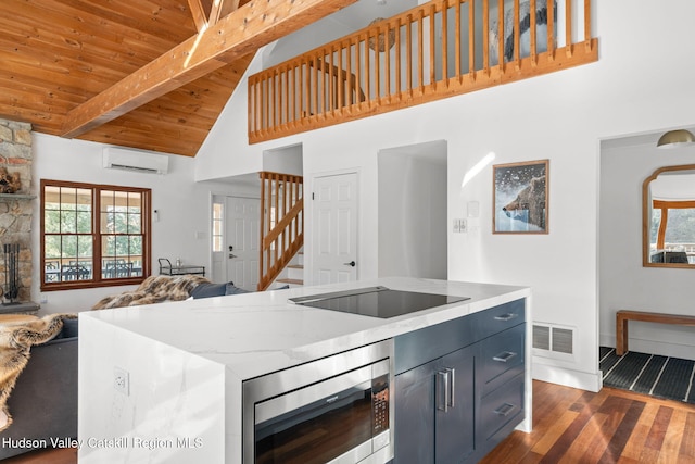 kitchen with beam ceiling, a wall unit AC, stainless steel microwave, black electric cooktop, and wooden ceiling