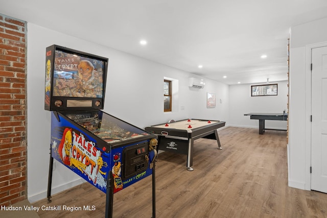 game room with hardwood / wood-style floors and an AC wall unit