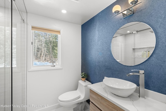 bathroom with walk in shower, vanity, and toilet