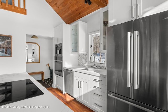 kitchen featuring white cabinetry, sink, backsplash, and appliances with stainless steel finishes