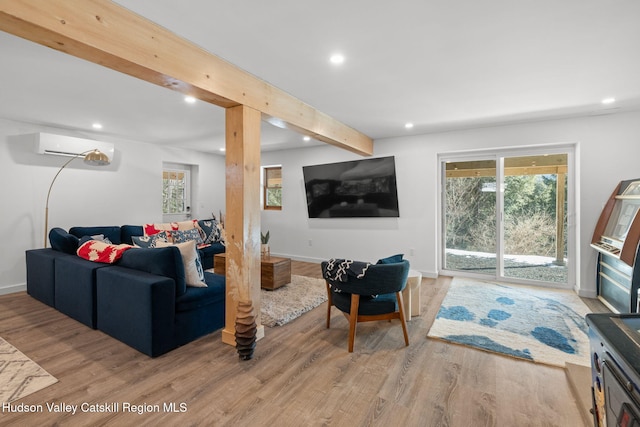 living room featuring wood-type flooring, beam ceiling, and a wall unit AC