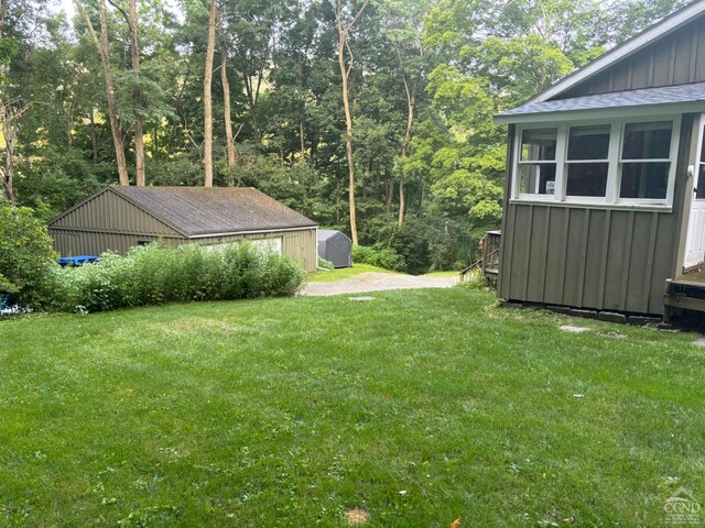 394 Peaceful Valley Rd, Canaan, NY 12029 - view of green lawn featuring an outdoor structure and a storage unit