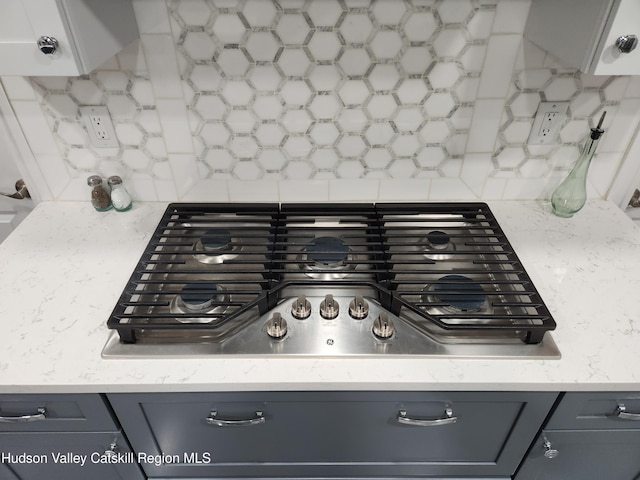 details featuring decorative backsplash, gray cabinets, and stainless steel gas cooktop