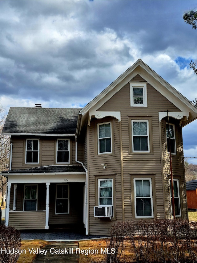 view of front of home with a porch, cooling unit, and a fenced front yard