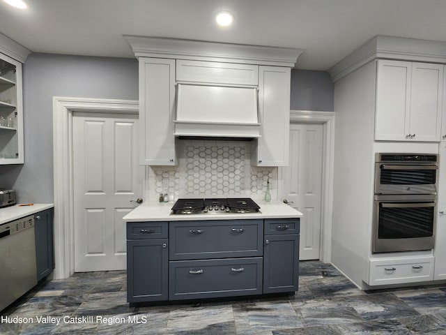 kitchen featuring tasteful backsplash, gray cabinetry, light countertops, appliances with stainless steel finishes, and white cabinets