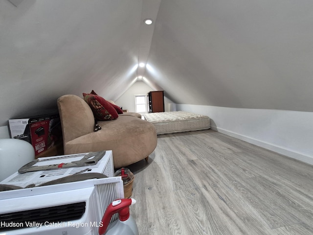 bedroom featuring baseboards, lofted ceiling, and wood finished floors