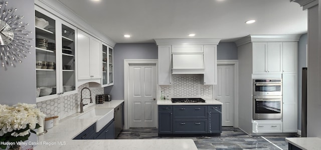 kitchen with a sink, gas stovetop, double oven, white cabinets, and dishwasher