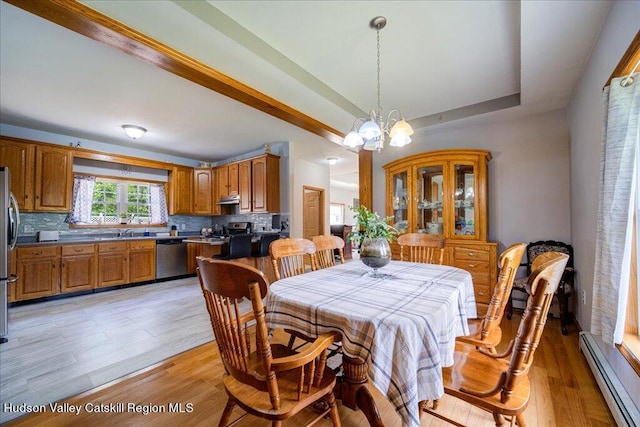 424 Joys Ln, Hurley, NY 12443 - dining room with baseboard heating, a chandelier, a raised ceiling, and light wood-type flooring