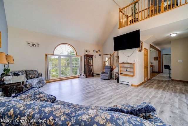 424 Joys Ln, Hurley, NY 12443 - living room with high vaulted ceiling, wood finished floors, stairs, baseboards, and a baseboard heating unit