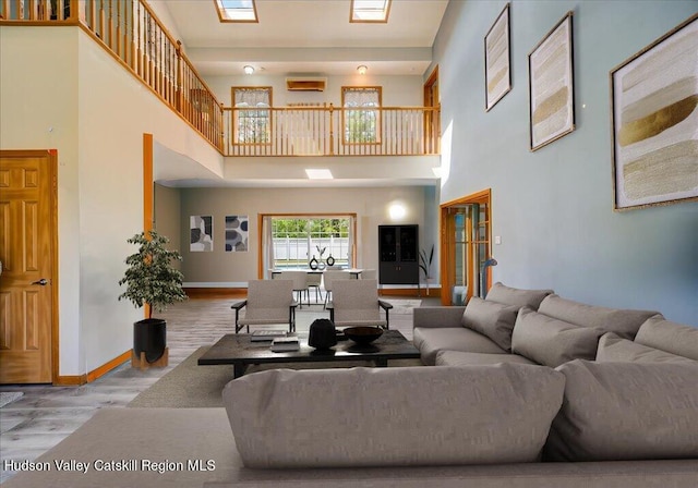 424 Joys Ln, Hurley, NY 12443 - living room featuring wood finished floors, a towering ceiling, and baseboards