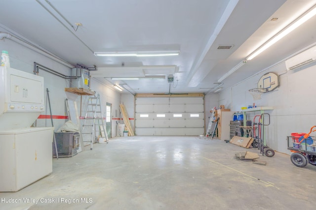 garage featuring a garage door opener, stacked washer and clothes dryer, and visible vents